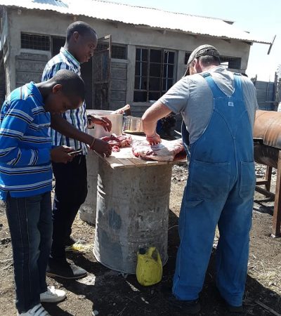 Jeremiah Gibbs(RIGHT) with friends, skinning and preparing one of the goats.